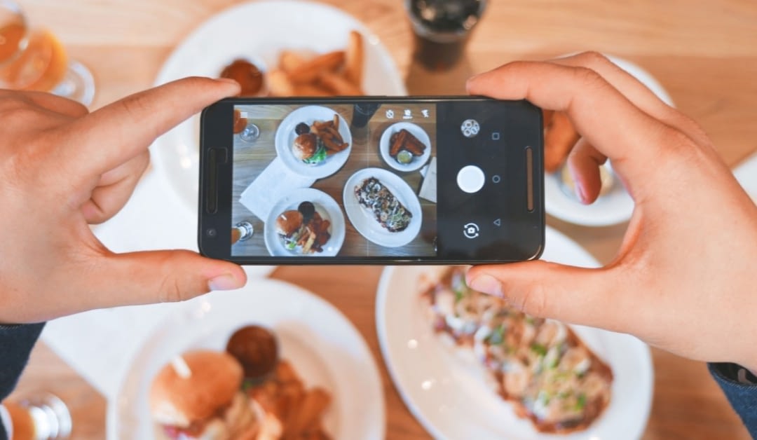 Image of a person taking a photo of their food.