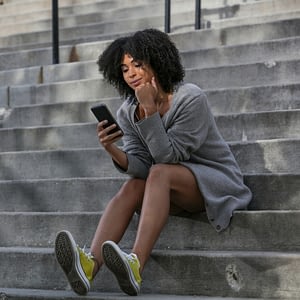 girl looking at phone on stairs